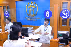 Người dân giải quyết thủ tục hành chính tại Trung tâm Phục vụ hành chính công Thành phố Hà Nội. (Ảnh: Văn Điệp/TTXVN)