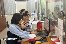 Giải quyết thủ tục hành chính cho người dân. (Ảnh: PV/Vietnam+)