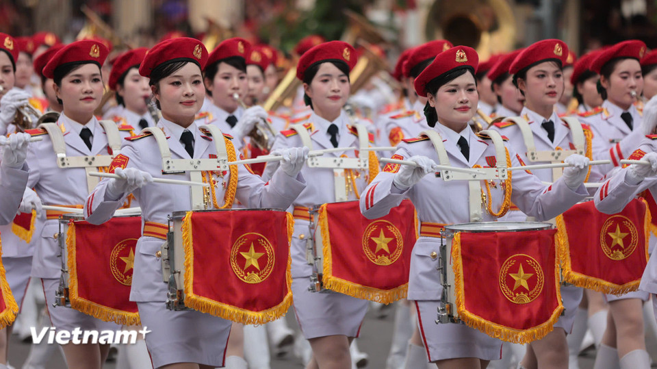 Khối nữ quân nhạc mặc quân phục màu trắng với các chi tiết đỏ và vàng, mang cấp hiệu, phù hiệu rõ ràng. (Ảnh: Hoài Nam/Vietnam+)