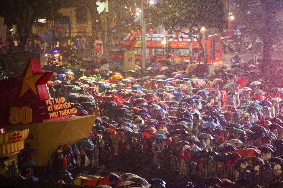Tiết trời Hà Nội tối nay khoảng 26 độ C, mưa khá to nhưng do đã chuẩn bị sẵn áo mưa, ô nên dòng người vẫn "yên vị" tại chỗ. (Ảnh: PV/Vietnam+)