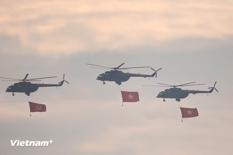 Trên bầu trời Hà Nội, lá cờ đỏ sao vàng và cờ Đảng tung bay kiêu hãnh theo nhịp cánh quạt trực thăng, khơi dậy niềm tự hào và xúc động trong lòng hàng nghìn người dân dõi theo từ dưới đường phố. (Ảnh: PV/Vietnam+)