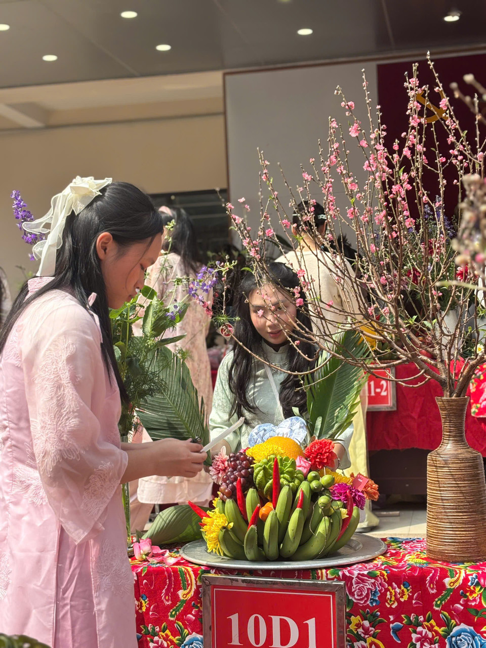 Các em học sinh lớp 10D1, Trường Trung học Phổ thông Trương Định khéo léo bày biện mâm ngũ quả ngày Tết cổ truyền của dân tộc. (Ảnh: PV/Vietnam+)