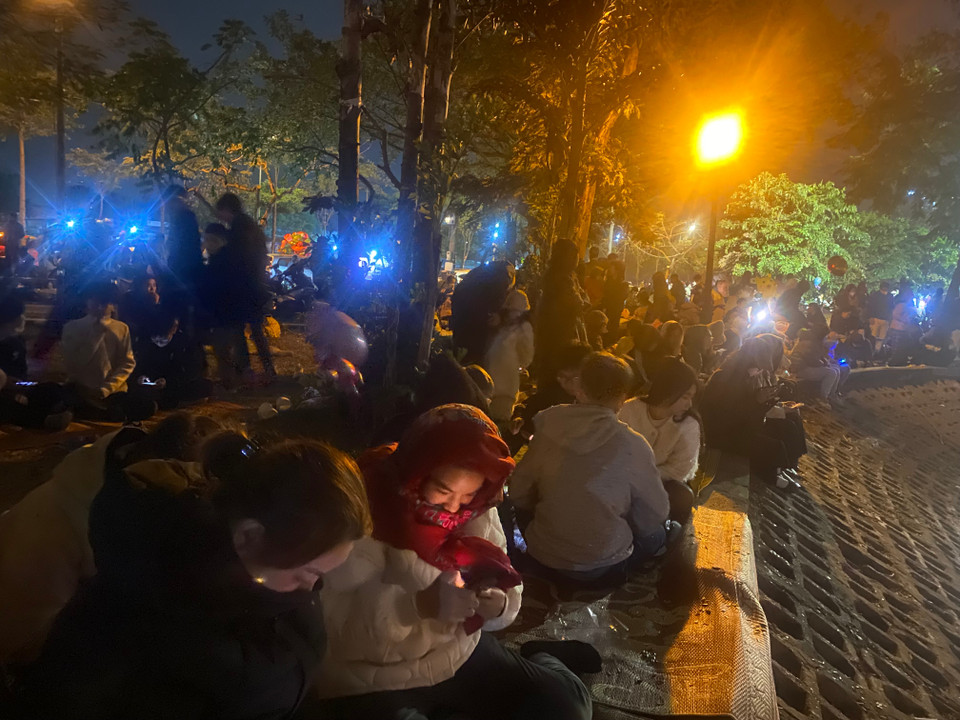 Nhiều người mang cả chiếu trải để ngồi chờ màn pháo hoa. (Ảnh: PV/Vietnam+)