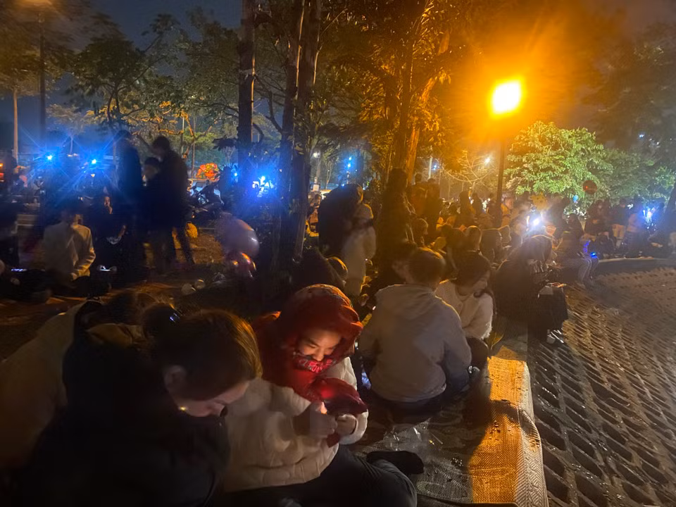 Nhiều người mang cả chiếu trải để ngồi chờ màn pháo hoa. (Ảnh: PV/Vietnam+)