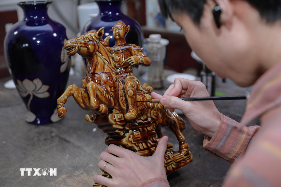 Công đoạn vẽ họa tiết, phối màu đòi hỏi sự tập trung cao độ. (Ảnh: Phan Phương/TTXVN)