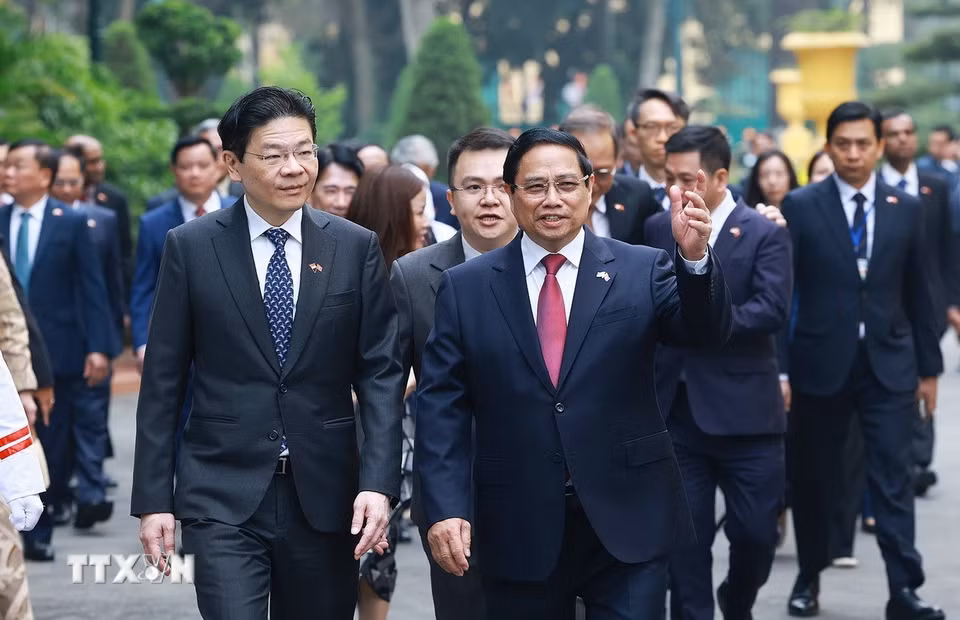 Thủ tướng Phạm Minh Chính đón Thủ tướng Singapore Lawrence Wong. (Ảnh: Dương Giang/TTXVN)