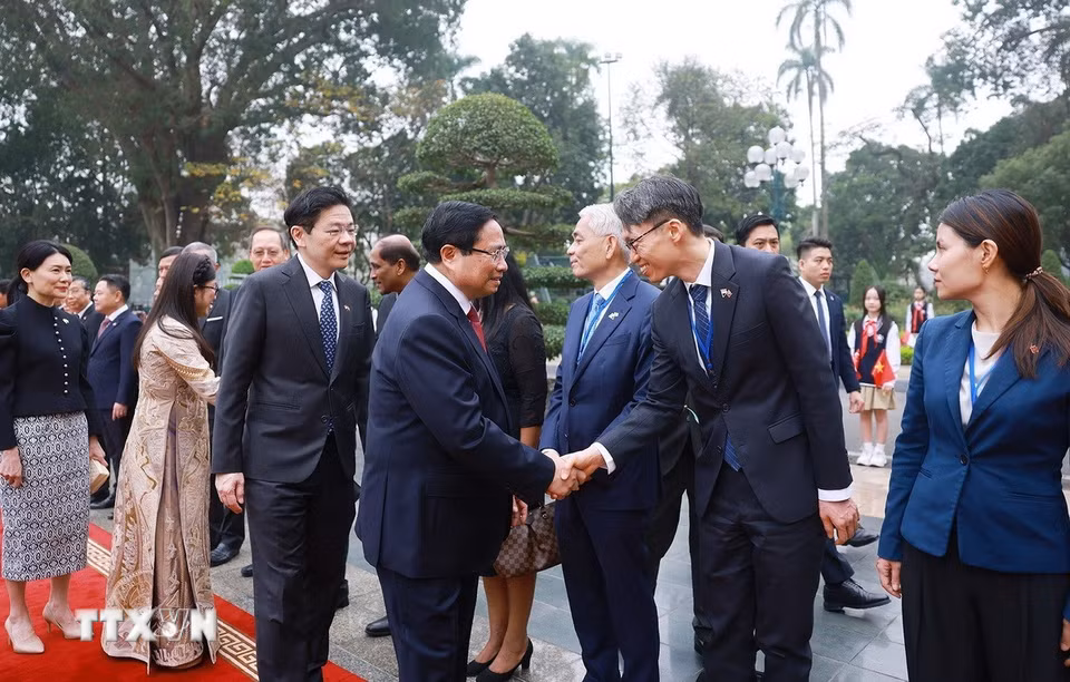 Thủ tướng Singapore Lawrence Wong giới thiệu với Thủ tướng Phạm Minh Chính thành viên đoàn Singapore. (Ảnh: Dương Giang/TTXVN)