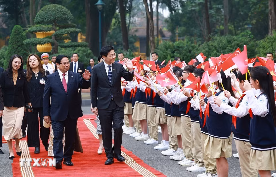 Thủ tướng Phạm Minh Chính và Phu nhân cùng Thủ tướng Singapore Lawrence Wong và Phu nhân với thiếu nhi Thủ đô. (Ảnh: Dương Giang/TTXVN)