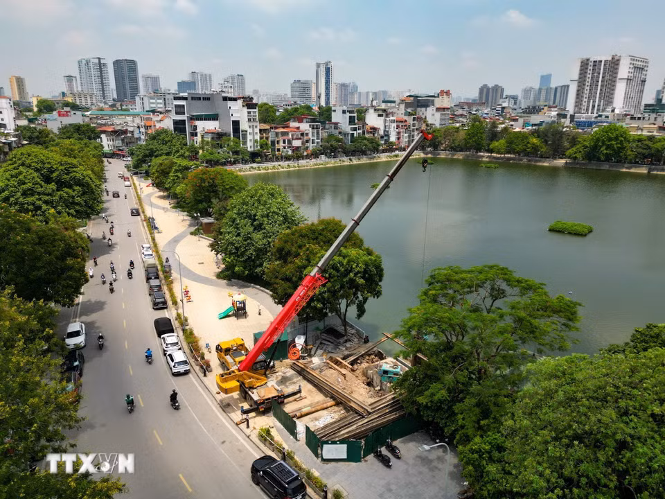 Đơn vị thi công sử dụng máy cẩu cọc thép và máy ép cừ để triển khai các hạng mục nền móng tại dự án nâng cấp trạm bơm hồ Xã Đàn, góp phần đẩy nhanh tiến độ công trình chống ngập. (Ảnh: Lê Đông/TTXVN)