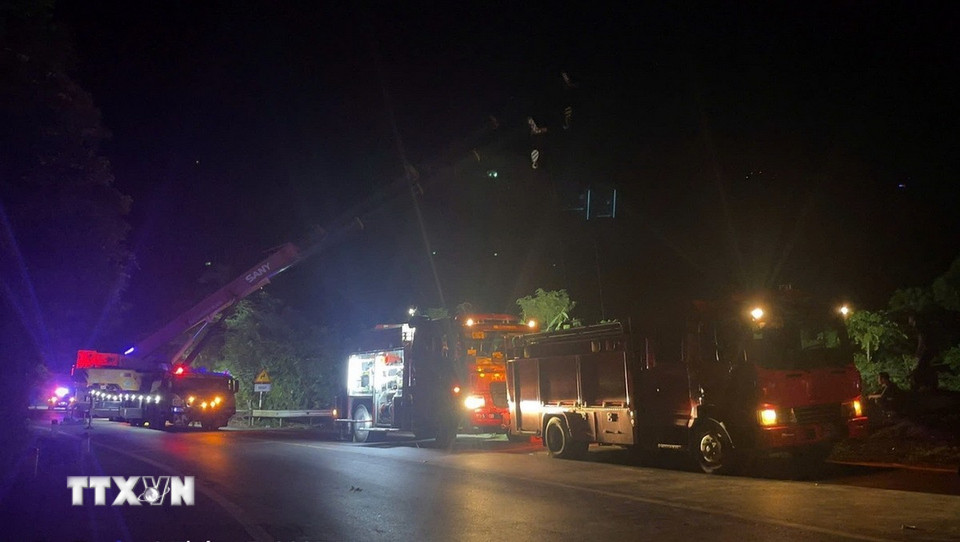 Các lực lượng chức năng bố trí phương tiện để cứu hộ cứu nạn tài xế bị mắc kẹt trong cabin xe container ở dưới vực sâu. (Ảnh: TTXVN phát)