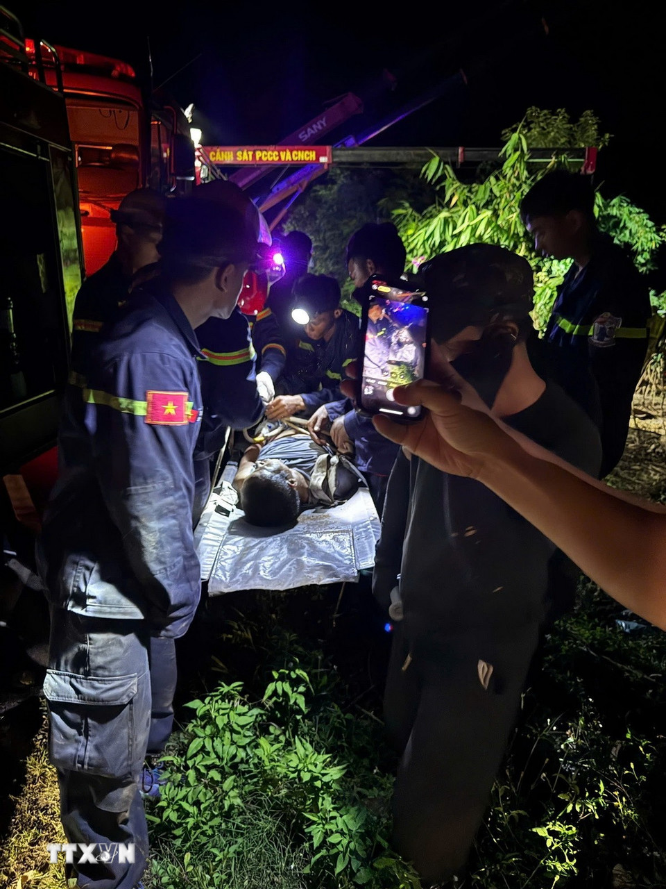 Lực lượng chức năng đưa tài xế ra khỏi cabin an toàn và chuyển đến cơ sở y tế để tiếp tục điều trị. (Ảnh: TTXVN phát)