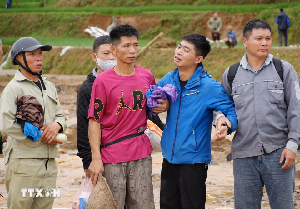 Nỗi đau của nhưng gia đình khi có nguời mất trong cơn lũ. (Ảnh: Nguyễn Oanh/TTXVN)