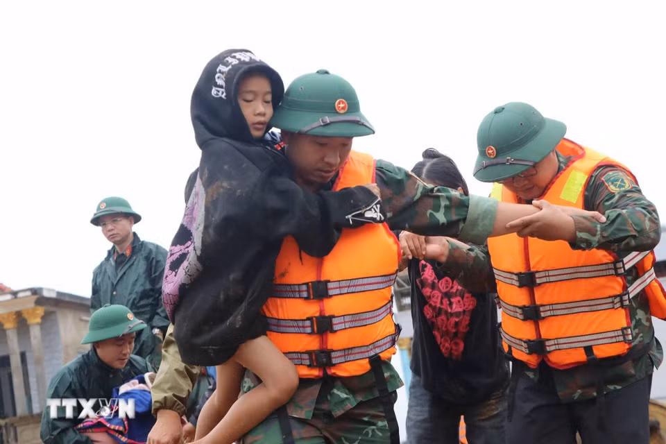 Các lực lượng cứu hộ giúp người dân di chuyển đến nơi an toàn. (Ảnh: Nguyễn Oanh/TTXVN)