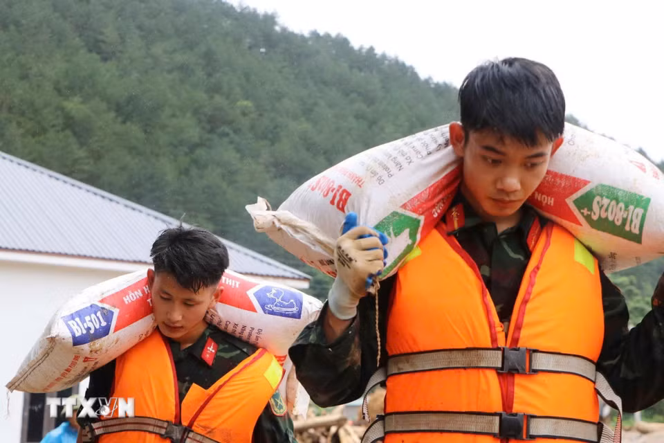 Các lực lượng cứu hộ của tỉnh Lai Châu giúp người dân Mường Than di dời tài sản đến nơi an toàn. (Ảnh: Nguyễn Oanh/TTXVN)