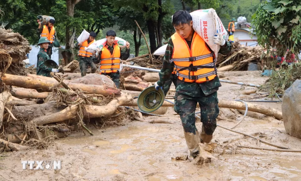 Các lực lượng cứu hộ của tỉnh Lai Châu giúp người dân Mường Than di dời tài sản đến nơi an toàn. (Ảnh: Nguyễn Oanh/TTXVN)