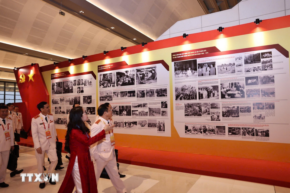 Đại biểu xem Trưng bày ảnh “Dưới cờ Đảng - Đất nước tiến vào Kỷ nguyên mới” do Thông tấn xã Việt Nam thực hiện. (Nguồn: TTXVN)