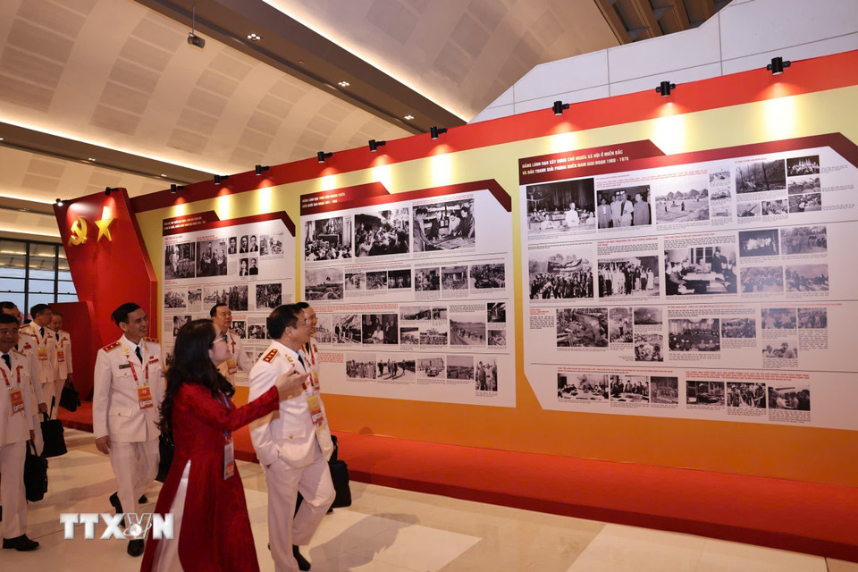 Đại biểu xem Trưng bày ảnh “Dưới cờ Đảng - Đất nước tiến vào Kỷ nguyên mới” do Thông tấn xã Việt Nam thực hiện. (Nguồn: TTXVN)