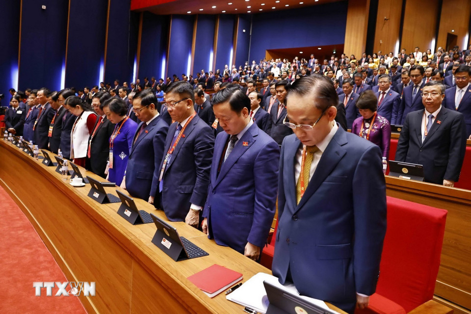 Các đại biểu dành 1 phút mặc niệm tưởng nhớ cố Tổng Bí thư Nguyễn Phú Trọng và các đồng chí Ủy viên Ban Chấp hành Trung ương khóa XIII đã từ trần trong nhiệm kỳ Đại hội XIII. (Ảnh: TTXVN)