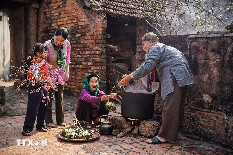 Các thế hệ trong gia đình quây quần bên bên nồi bánh chưng. (Ảnh: Khánh Hòa/TTXVN)