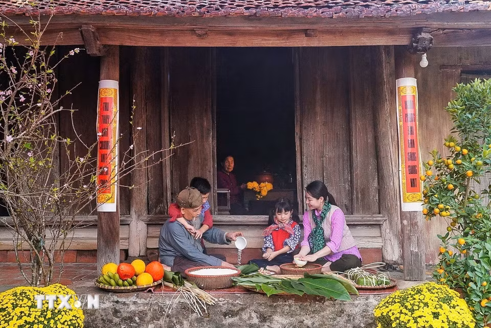Các thành viên trong gia đình cùng nhau gói bánh chưng – một loại bánh truyền thống không thể thiếu trong dịp Tết đến Xuân về. (Ảnh: Khánh Hòa/TTXVN)