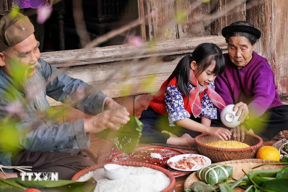 Các thế hệ quây quần gói bánh chưng mỗi dịp Tết đến Xuân về là nét đẹp trong văn hóa người Việt. (Ảnh: Khánh Hòa/TTXVN)