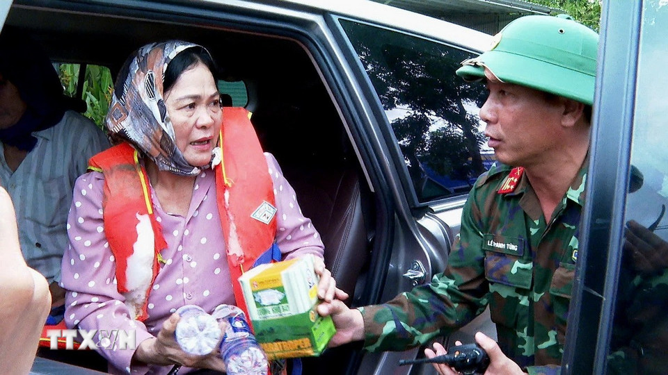 Đại tá lê Thanh Tùng, Phó Chỉ huy trưởng Bộ Chỉ huy quân sự tỉnh Gia Lai thăm hỏi, động viên người dân vừa được giải cứu vì bị mắc kẹt do mưa lũ. (Ảnh: Hồng Điệp/TTXVN)