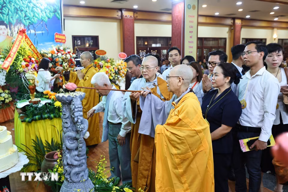 Các đại biểu và Phật tử thực hiện nghi thức tắm Phật. (Ảnh: Minh Đức/TTXVN)
