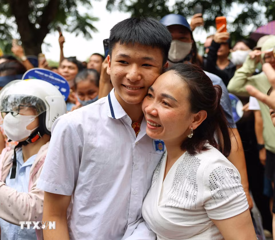 Phụ huynh vui mừng đón thí sinh sau khi hoàn thành môn thi đầu tiên tại điểm thi Trường THPT Trần Nhân Tông. (Ảnh: Thanh Tùng/ TTXVN)