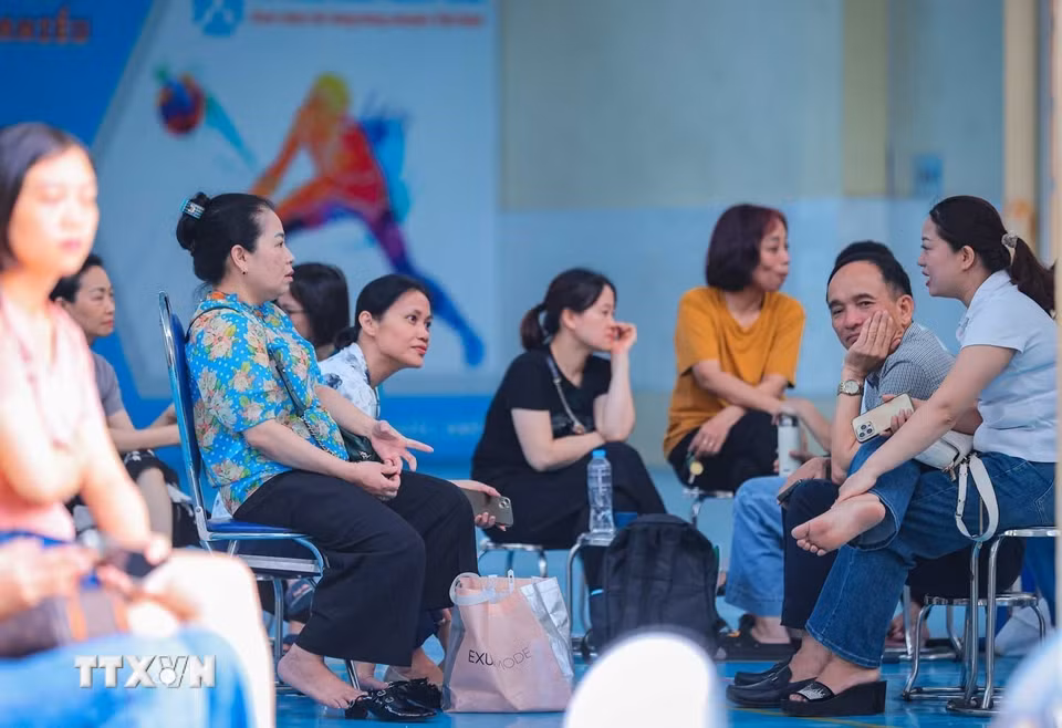 Dù mưa to hay nắng gắt, các bậc phụ huynh vẫn kiên trì chờ đợi thí sinh thi bên ngoài điểm thi. (Ảnh: Hoàng Hiếu/ TTXVN)