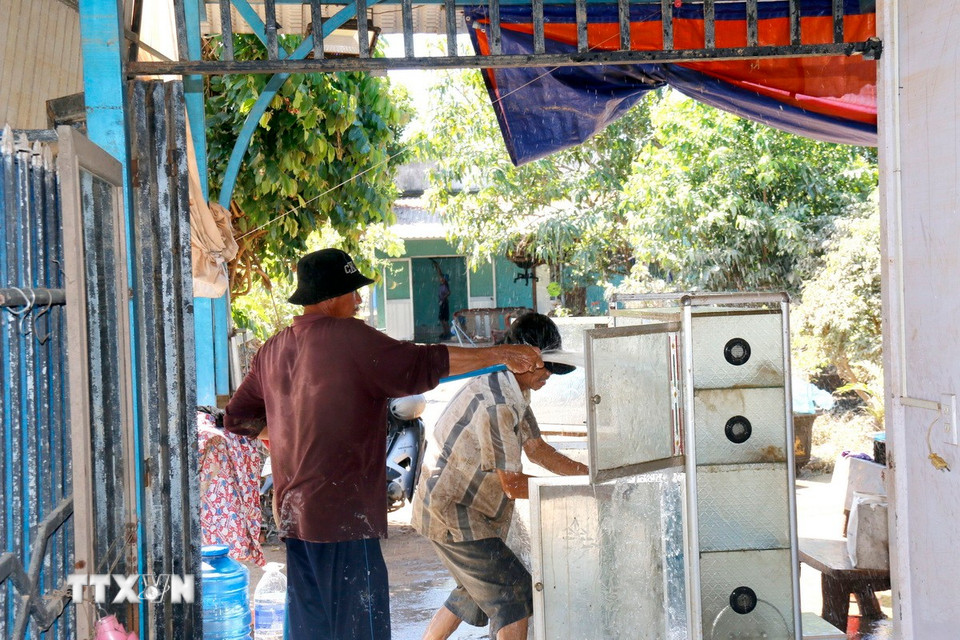 Người dân phường Hàm Thắng (Lâm Đồng) dọn dẹp nhà cửa sau lũ. (Ảnh: Nguyễn Thanh/TTXVN)