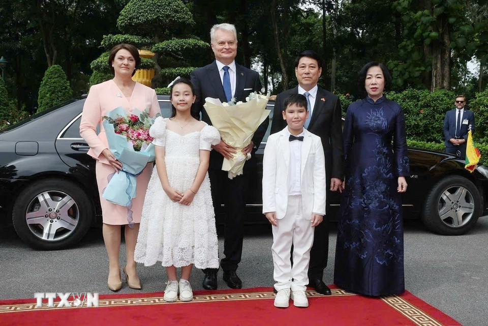 Chủ tịch nước Lương Cường và Phu nhân cùng Tổng thống Cộng hòa Litva Gitanas Nauseda và Phu nhân với thiếu nhi Thủ đô tại lễ đón. (Ảnh: Lâm Khánh/TTXVN)