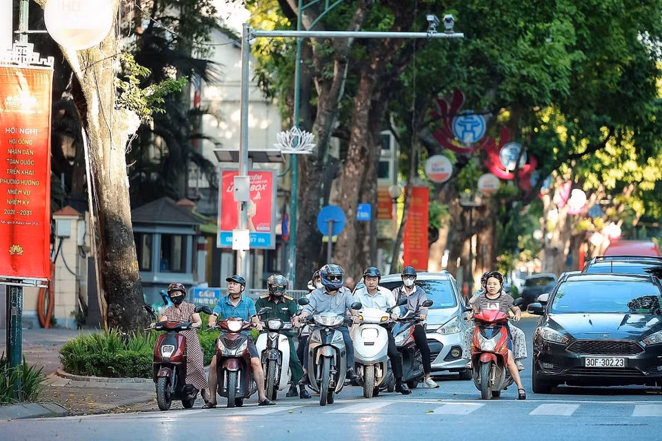 Nhiều người tranh thủ đi làm sớm hơn mọi ngày để tránh giờ cao điểm và nắng lên. (Ảnh: Phạm Tuấn Anh/TTXVN)