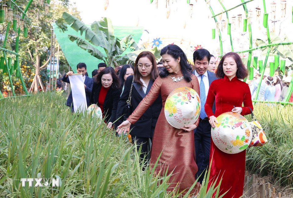 Bà Ngô Phương Ly, Phu nhân Tổng Bí thư Tô Lâm với các đại biểu tham quan và trải nghiệm tại đường hoa. (Ảnh: Văn Điệp/TTXVN)