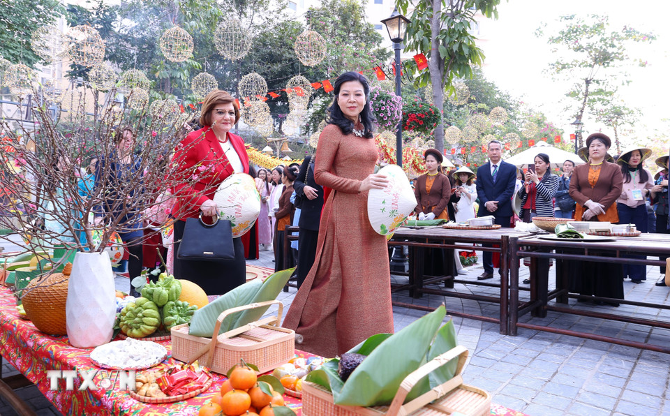 Bà Ngô Phương Ly, Phu nhân Tổng Bí thư Tô Lâm với các đại biểu tham quan gian trưng bày Tết Việt. (Ảnh: Văn Điệp/TTXVN)