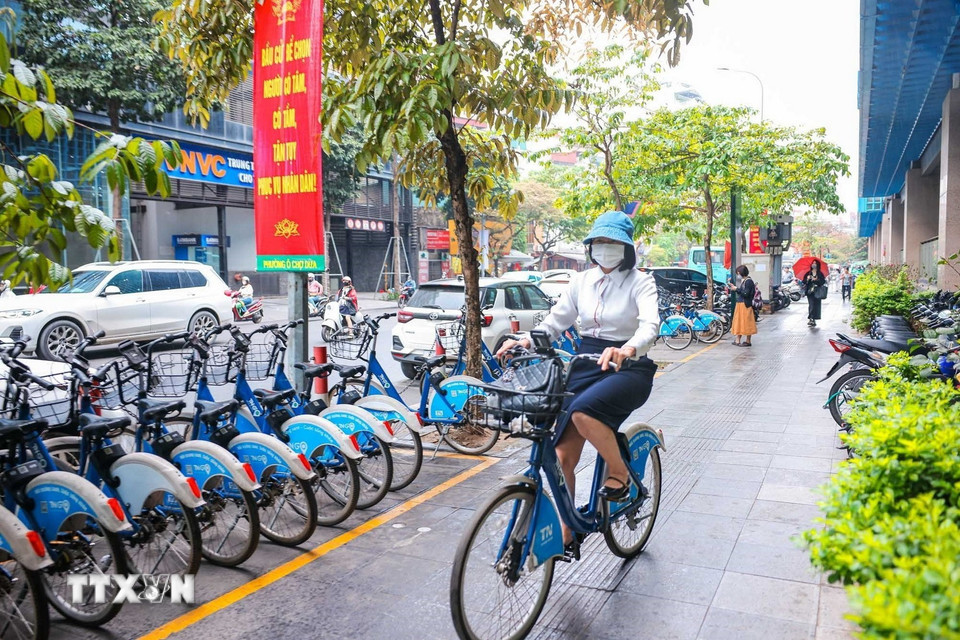 Nhiều người dân còn sử dụng dịch vụ xe đạp (cơ, điện) công cộng của TNGo, một hình thức giao thông đô thị mới, thân thiện với môi trường. (Ảnh: Hoàng Hiếu/ TTXVN)