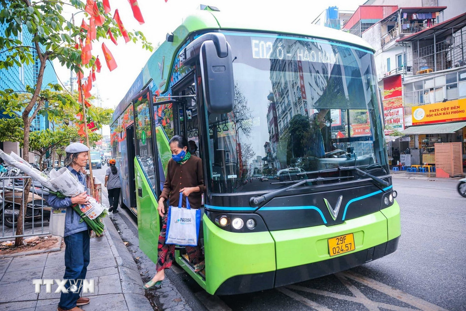 Hành khách lên xe buýt điện tại đường Cầu Giấy. (Ảnh: Hoàng Hiếu/TTXVN)
