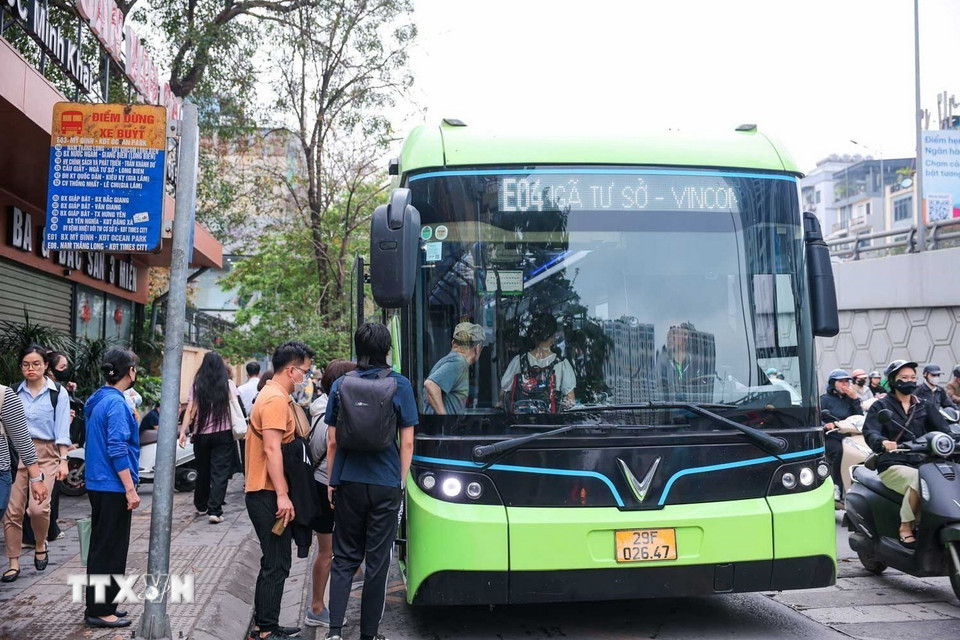 Hành khách lên xe buýt điện tại đường Cầu Giấy. (Ảnh: Hoàng Hiếu/TTXVN)