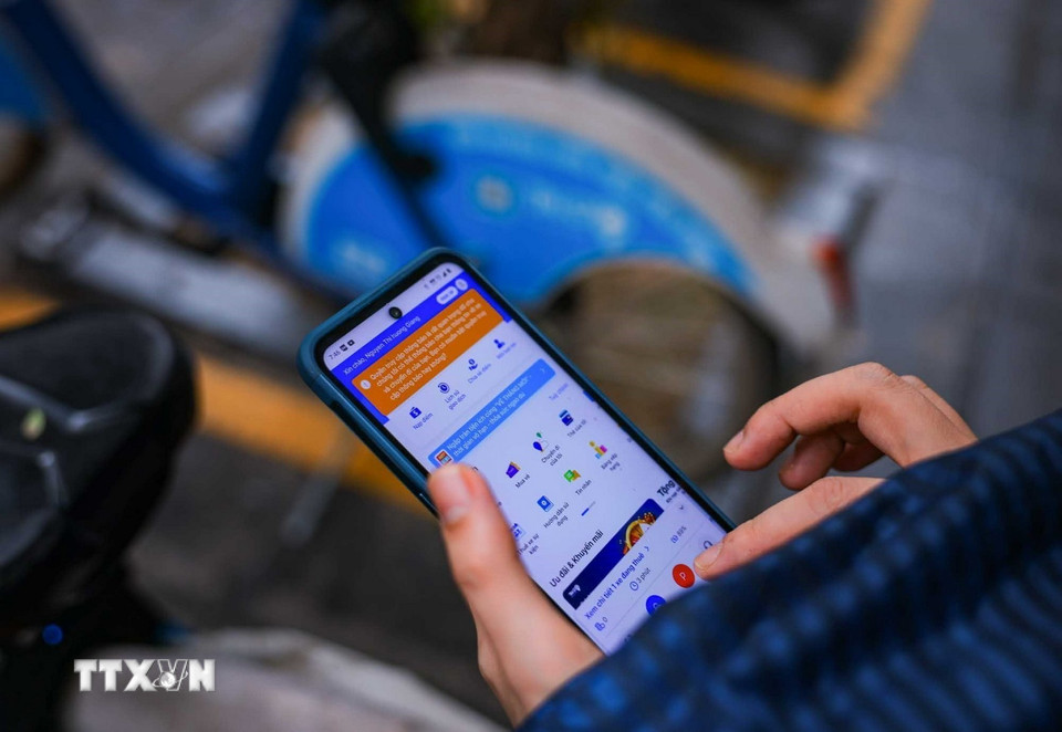 Người dân sử dụng ứng dụng thuê xe điện tự lái khi cần di chuyển. (Ảnh: Hoàng Hiếu/TTXVN)