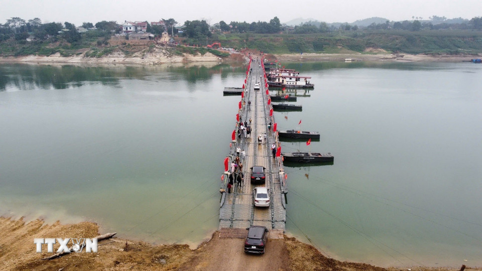 Người và phương tiện lưu thông bình thường qua cầu phao sông Lô sáng 16/2. (Ảnh: Nguyễn Văn Cảnh/TTXVN)
