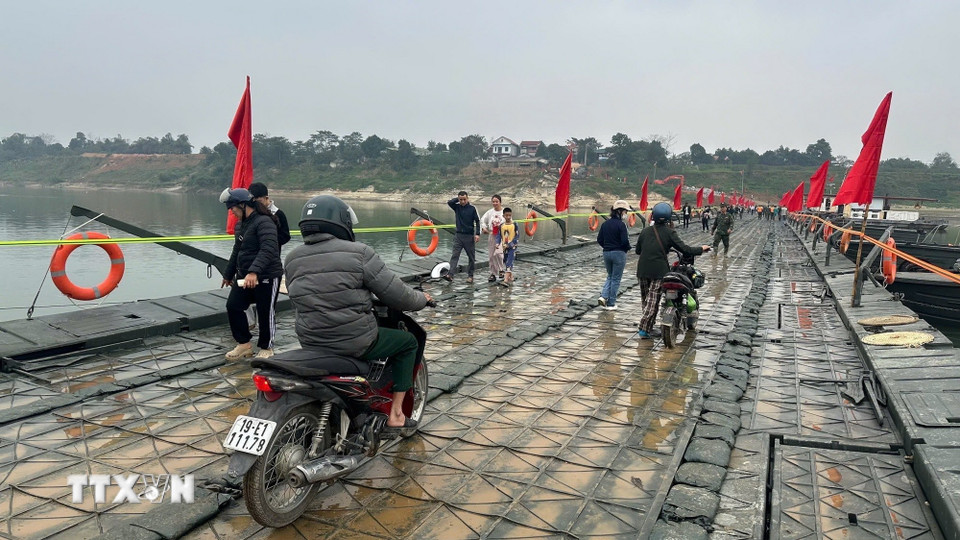 Người và phương tiện lưu thông bình thường qua cầu phao sông Lô sáng 16/2. (Ảnh: Nguyễn Văn Cảnh/TTXVN)
