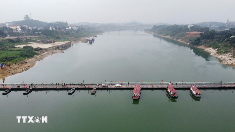 Người và phương tiện lưu thông bình thường qua cầu phao sông Lô sáng 16/2. (Ảnh: Nguyễn Văn Cảnh/TTXVN)