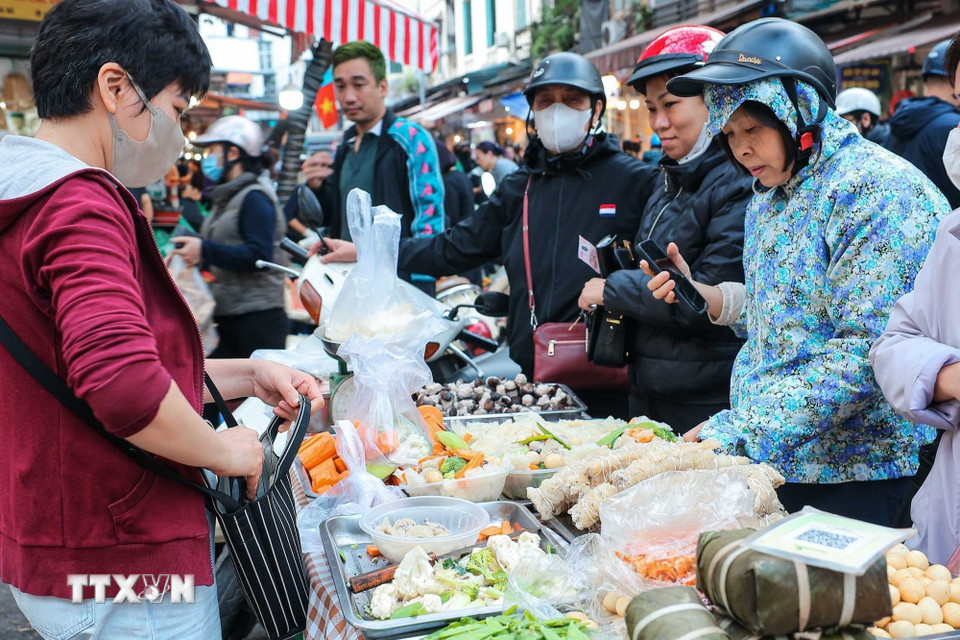 Người dân chọn mua thực phẩm về để sửa soạn mâm cỗ tưởng nhớ tổ tiên. (Ảnh: Hoàng Hiếu/TTXVN)