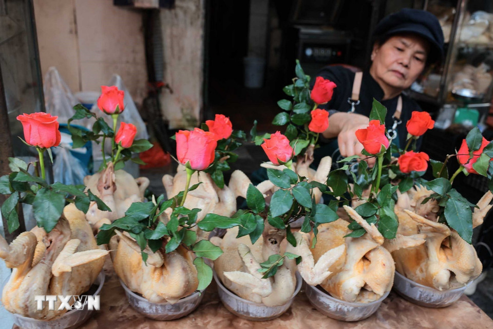 Chuẩn bị gà ngậm hoa sen, buộc cánh tiên tại chợ Hàng Bè trong phiên chợ cuối năm. (Ảnh: Hoàng Hiếu/TTXVN)