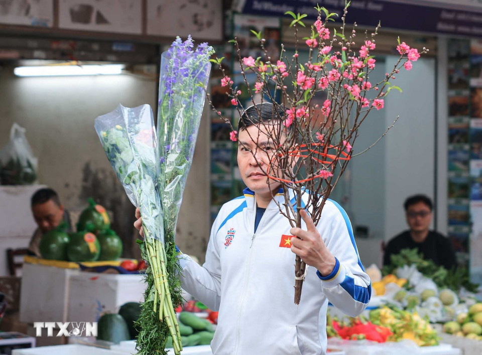 Theo phong tục truyền thống, người dân thường chọn mua những bó hoa tươi trong phiên chợ cuối năm để trang hoàng nhà cửa và dâng lên bàn thờ gia tiên. (Ảnh: Hoàng Hiếu/TTXVN)