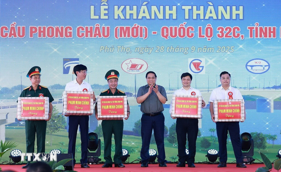 Thủ tướng Phạm Minh Chính tặng quà cho nhà thầu và các đơn vị thi công dự án cầu Phong Châu mới. (Ảnh: Dương Giang/TTXVN)