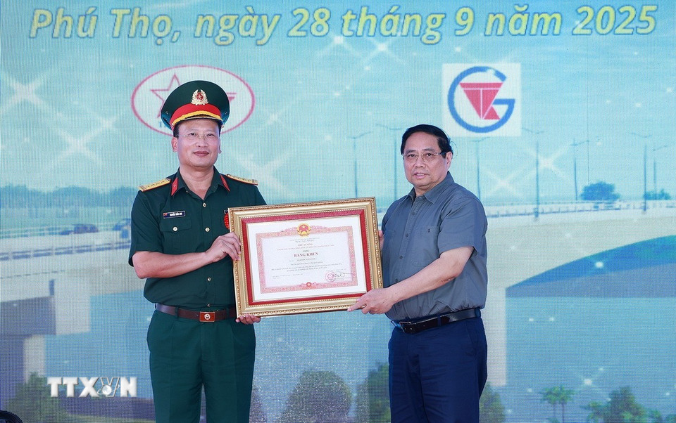 Thủ tướng Phạm Minh Chính tặng bằng khen cho đồng chí Nguyễn Tuấn Anh, Phó Tư lệnh Binh đoàn 12, Bộ Quốc phòng có thành tích xuất sắc trong tổ chức thi công dự án cầu Phong Châu mới. (Ảnh: Dương Giang/TTXVN)