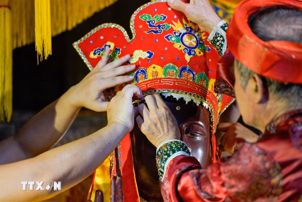 Thực hiện nghi thức "Phong áo Phật" - một trong nghi thức độc đáo hiếm nơi còn lưu giữ của lễ hội làng Keo. (Ảnh: Khánh Hòa/TTXVN)