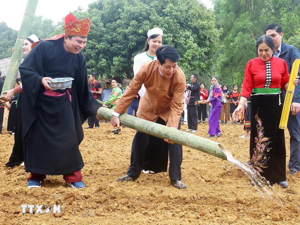 Chủ tịch nước Lương Cường thực hiện nghi thức tưới nước trong Lễ xuống đồng của dân tộc Mường. (Ảnh: Lâm Khánh/TTXVN)