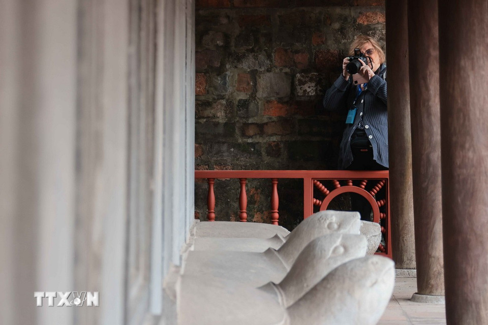 Du khách lưu giữ kỷ niệm khi đến với Văn Miếu-Quốc Tử Giám. (Ảnh: Hoàng Hiếu/TTXVN)