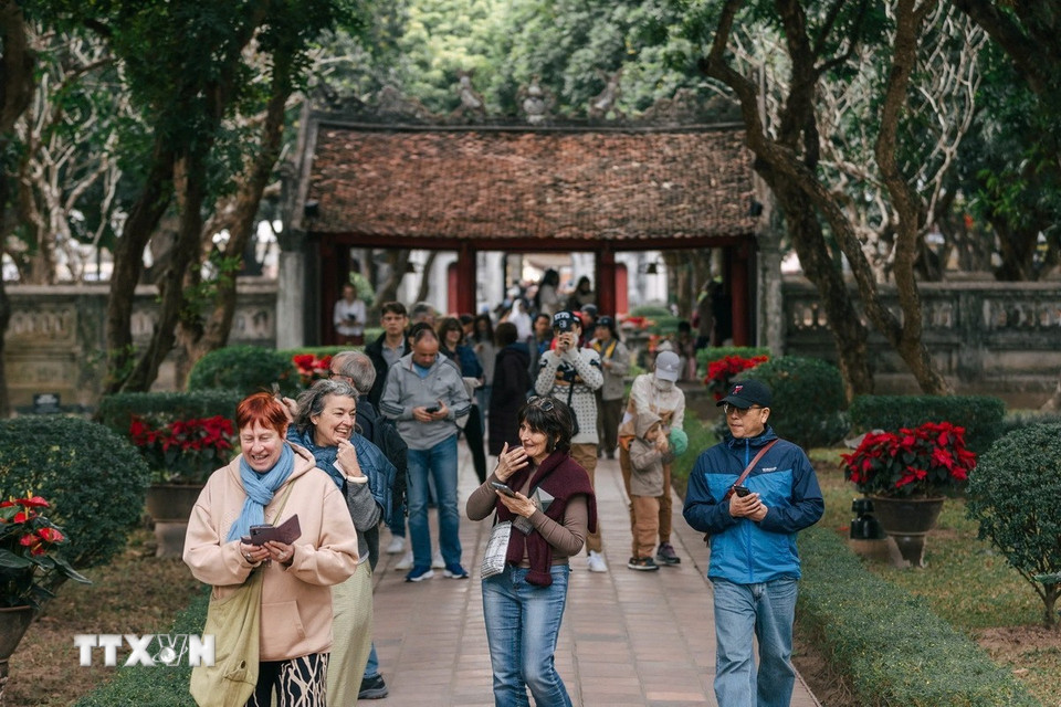 Du khách tìm hiểu về lịch sử tại Văn Miếu-Quốc Tử Giám. (Ảnh: Phạm Tuấn Anh/TTXVN)